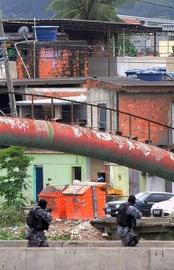 PM paramilitary police personnel man a checkpoint on a bridge in the Cidade de Deus shantytown, 10km from the Olympic Village Rio de Janeiro, Brazil on July 21, 2016. Brazilian police have arrested 10 members of an "amateur" would-be terrorist group that expressed loyalty to the Islamic State organization and was targeting the upcoming Olympics, officials said Thursday. / AFP PHOTO / Tony Barros